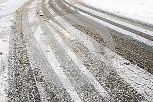 Bend of wet slippery city snowy road in winter