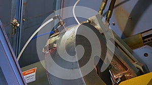 Bending and cutting of metal tubes on industrial CNC machine in factory.