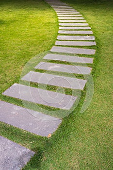 Bending garden stone path at night with glowing light from garden outdoor light