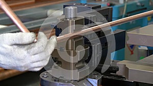 Bending of metal tubes on industrial machine in factory.