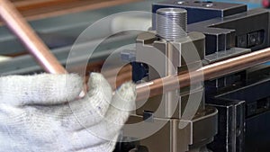 Bending of metal tubes on industrial machine in factory.