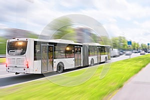 Bendy bus driving in city traffic in motion blur