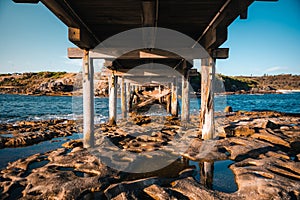 Beneath view of the Bare Island Bridge on the rocky shore in La Perouse, Sydney, Australia