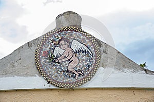 Roof with an antique oval mosaic of a winged cherub bringing a rose.