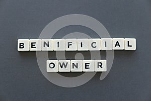 Beneficial owner word made of square letter word on grey background.