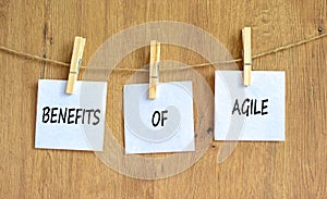 Benefits of agile symbol. Concept words Benefits of agile on beautiful white paper on clothespin. Beautiful wooden table wooden