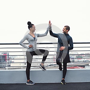 The benefits of exercise linger long after. a sporty young man and woman giving each other a high five while exercising