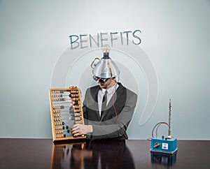 Benefits text on blackboard with businessman