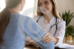 Benevolent woman practitioner encouraging young girl customer to take treatment