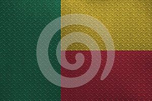 Benin flag depicted in paint colors on old brushed metal plate or wall closeup. Textured banner on rough background