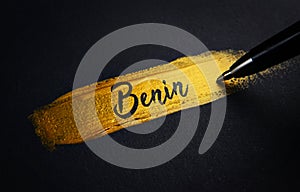 Benin Handwriting Text on Golden Paint Brush Stroke