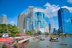Benjakitti Park in Bangkok, Thailand. Panoramic view of buildings, lake and trees on a sunny day