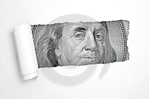 Benjamin franklin on a hundred dollar bill in the hole of torn white paper. 3d rendering