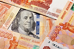 Benjamin Franklin on a hundred dollar bill surrounded by Russian rubles with a face value of five thousand each