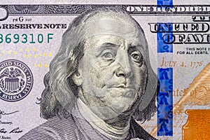 Benjamin Franklin`s face in close-up on a US hundred dollar bill