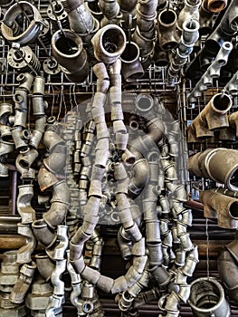 Bent pieces of rusted metal pipes hanging garland in a metal workshop