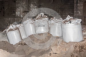 Bentonite clay powder packed in bags at an industrial plant for processing sand, soil and land