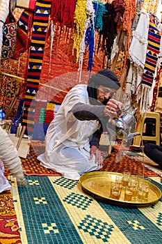 Berber man pouring tea in a carpet shop