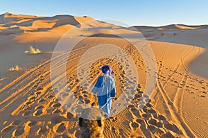 Berber walking with camel at Erg Chebbi, Morocco