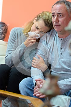 bereaved father and daughter crying and supporting each other