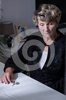 Bereaved woman sitting beside table photo
