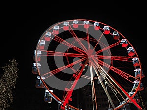 Bergamo, Italy. The Ferris wheel illuminated in red in the evening. Christmas time