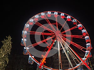 Bergamo, Italy. The Ferris wheel illuminated in red in the evening. Christmas time
