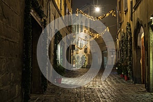BERGAMO, ITALY - 12, JANUARY. Old European narrow empty street of medieval town with Christmas decoration on a foggy