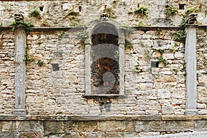 Bergamo, Italy. Stone wall old overgrown with green plants.