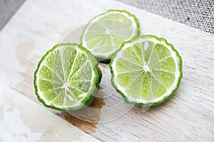 Bergamot fruit cutting slices on wooden clipping board on sackcloth background. Bergamot material of essential oils for beauty and