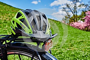 Yellow bike helmet lying on the luggage rack of a bicycle