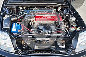 Berlin, Germany - August 20, 2022: Detail car view of engine bay enhanced Honda DOHC VTEC engine selective focus shot.