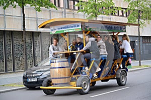 BERLIN, GERMANY. Young people in a beer bike ride down the street