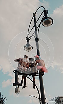 Berlin, Germany - 7/27/2019: Christopher street day in Berlin, young people siting on a light pole. Berlin pride