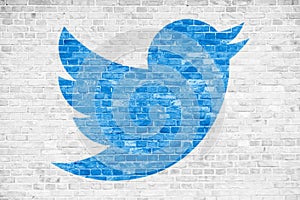 Twitter social media blue bird sign logo symbol in minimalist design painted over white brick wall background