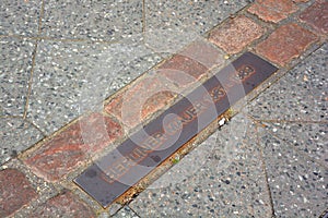 Sign on the road to show the place of the old Berlin Wall.