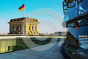 Berlin, Germany: The Reichstag -Bundestag- building in Berlin. The flag of Germany develops against the sky