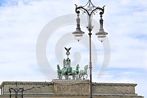 Berlin, Quadriga on Brandenburg Gate and nostaligic street lamp. Old gas lantern with wrought iron decoration. Berlin, Germany