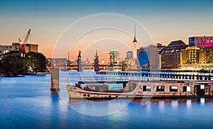 Berlin skyline with old ship wreck in Spree river at dusk, Germany