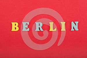 BERLIN word on red background composed from colorful abc alphabet block wooden letters, copy space for ad text. Learning english