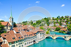 Bern, the capital of Switzerland, with dominant Nydegg Church and historical center located along turquoise Aare River. Bridge