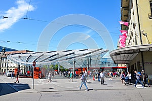 Bern, Switzerland - August 14 2019: People walking in the center of the Swiss capital near the main train station. Red tram in