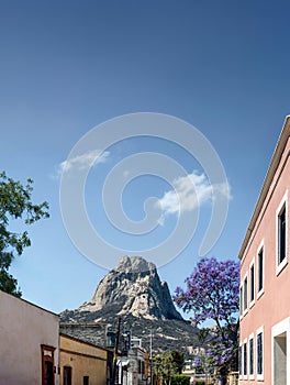 Bernal Peak, Monolith in Queretaro, Mexico, Mexican town with old houses and jacaranda flowers, with space for text above