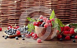 Berries closeup colorful assorted mix of strawberry, blueberry, raspberry and sweet cherry on a old wooden table