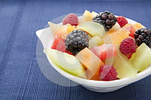 Berries and diced melon in a bowl on the table