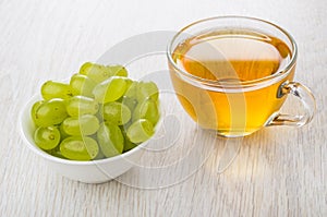 Berries of grape in bowl, transparent cup with grape juice