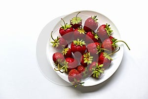 Berries of ripe and delicious strawberries on a white plate