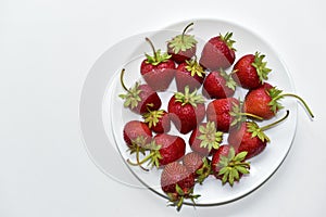 Berries of ripe and delicious strawberries on a white plate