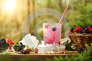 Berries slush with fruit around on table and nature background