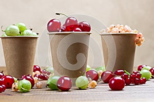 Berries of white currants, green gooseberries, cherries in paper caps